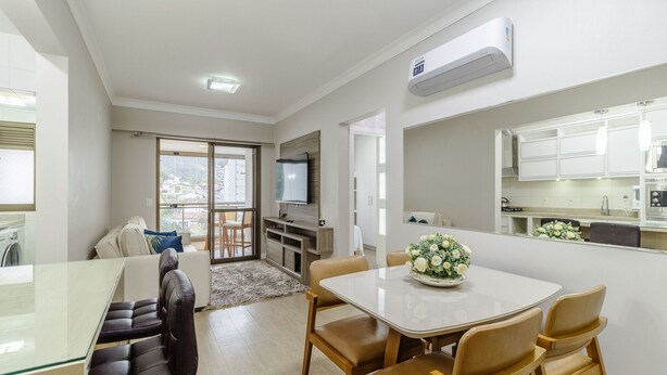 Un salon moderne avec une table à manger en verre, des fauteuils en cuir, un canapé et un téléviseur.