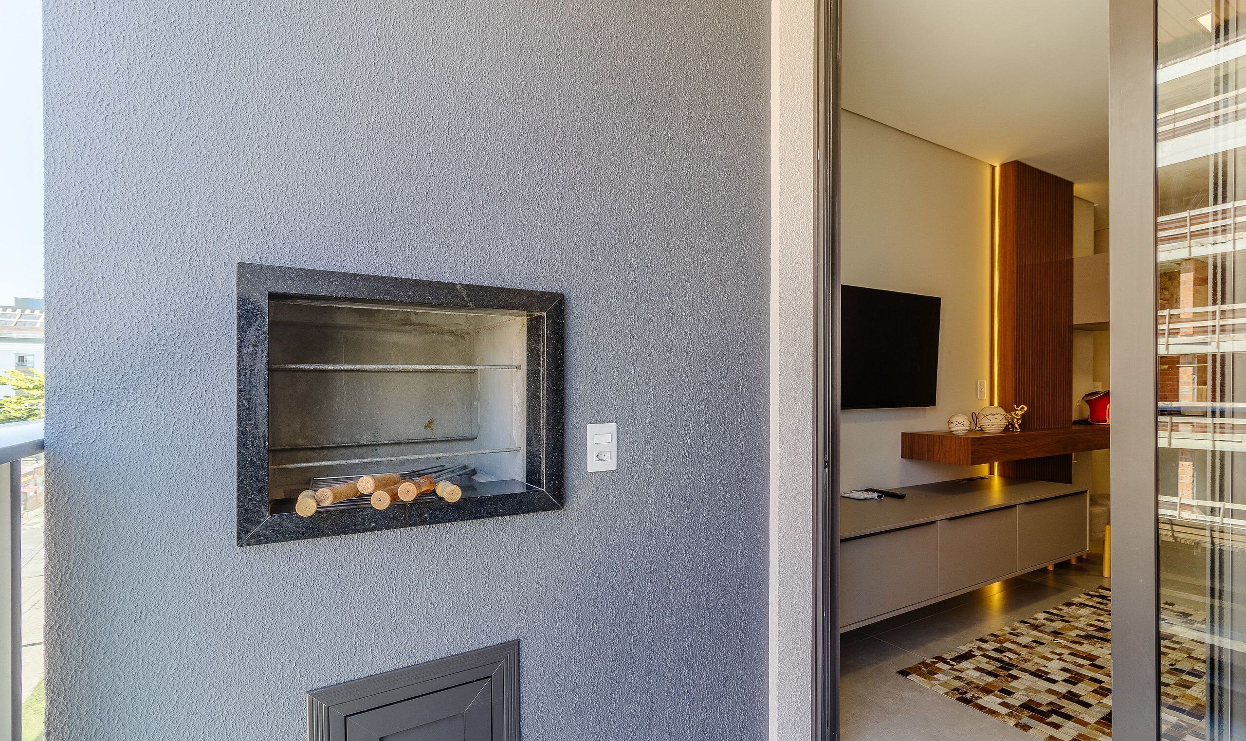 Eine moderne Küche mit Einbauofen, Flachbildfernseher und Holzschrank.