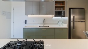 A modern kitchen with a stainless steel refrigerator, a gas stove, and a microwave. - Balcony With sea View 230m From the Beach! Prb0405 (Florianópolis)