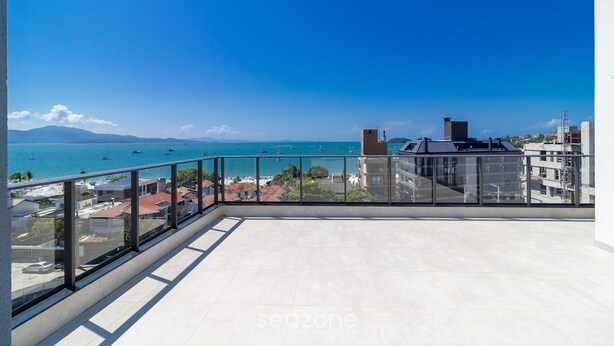 A balcony with a clear view of the sea and boats, a glass railing, and a tiled floor. - Balcony With sea View 230m From the Beach! Prb0405 (Florianópolis)