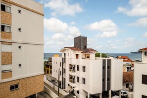 Un edificio de varios pisos con balcones, vista al mar y cielo despejado.
