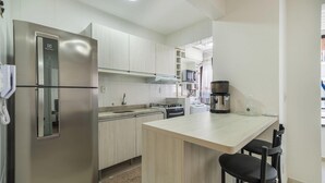 A modern kitchen with stainless steel appliances, a gas stove, and a coffee maker. - Apartment w/ Barbecue 450m From the Beach Pnm0202 (Florianópolis)