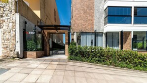 A modern building with a stone facade, a glass entrance, and a clear sky. - Charming Studio Just 200m From the Beach - Pmo0404 (Florianópolis)