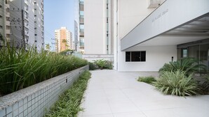 A modern building with a tiled pathway and green plants. - Apt Floripa, 50m to the Beach - Pad0103 (Florianópolis)