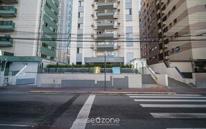 A multi-story residential building with balconies, a gated entrance, and a staircase leading to the entrance. - Apt Floripa, 50m to the Beach - Pad0103 (Florianópolis)