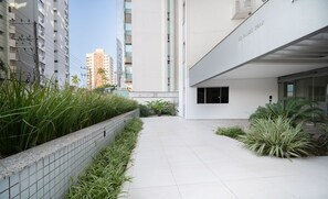 A modern building with a tiled pathway and green plants. - Apt Floripa, 50m to the Beach - Pad0103 (Florianópolis)