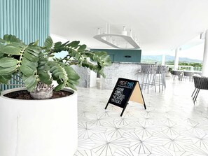 Un intérieur moderne agrémenté d’une plante en pot, d’un tableau noir servant de menu et d’un espace salon offrant une vue agréable.