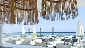 Una terraza con mobiliario exterior, vistas al mar y un diseño moderno.