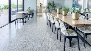 Una sala de reuniones moderna con una mesa larga, sillas y plantas en macetas.