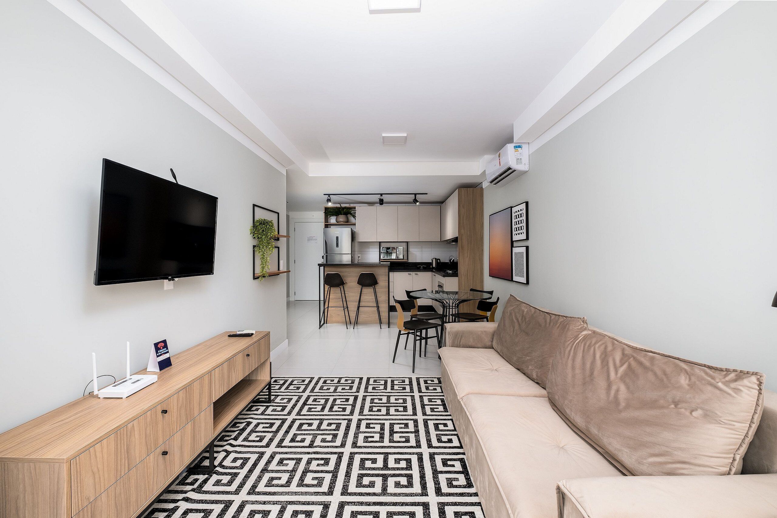 A modern living room with a sofa, a TV, and a wooden console table.