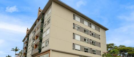 A multi-story building with balconies, large windows, and a flat roof.