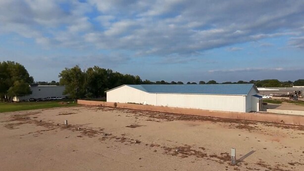 A large, single-story building with a flat roof and a long, rectangular structure. - Next Door to the Fair RV Park (Spencer)