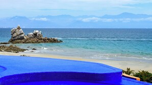 A pool with a view of the ocean and mountains in the background.