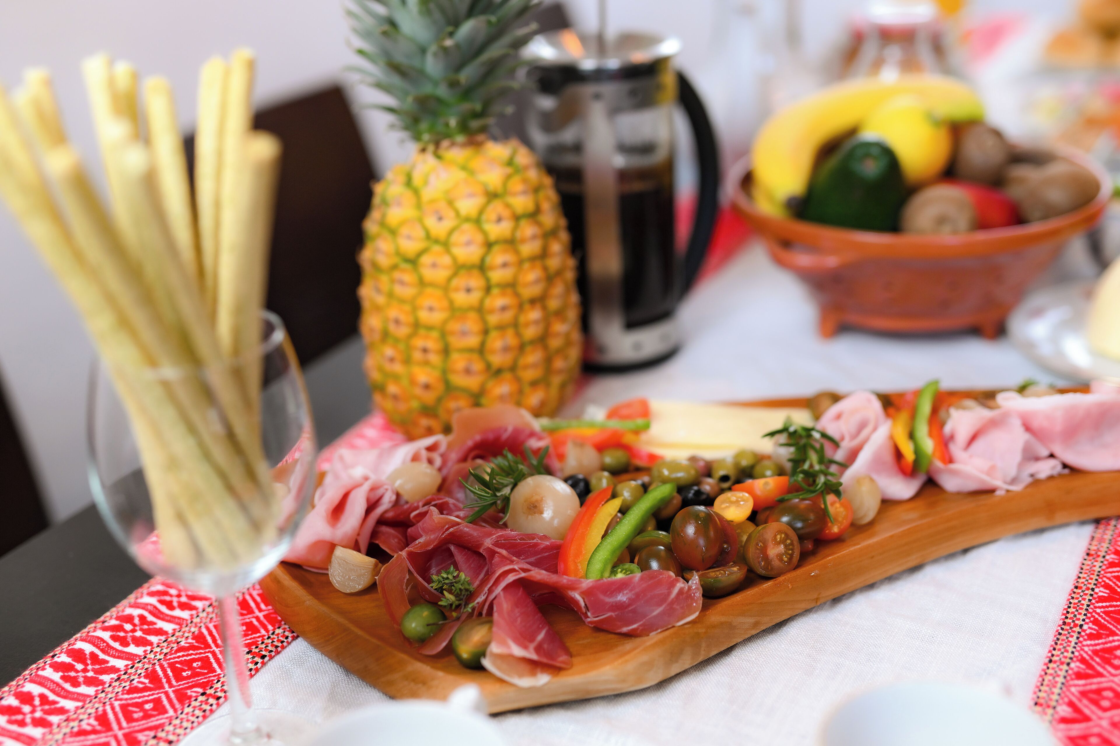 Una tabla de embutidos con diversos quesos, carnes, aceitunas y verduras.