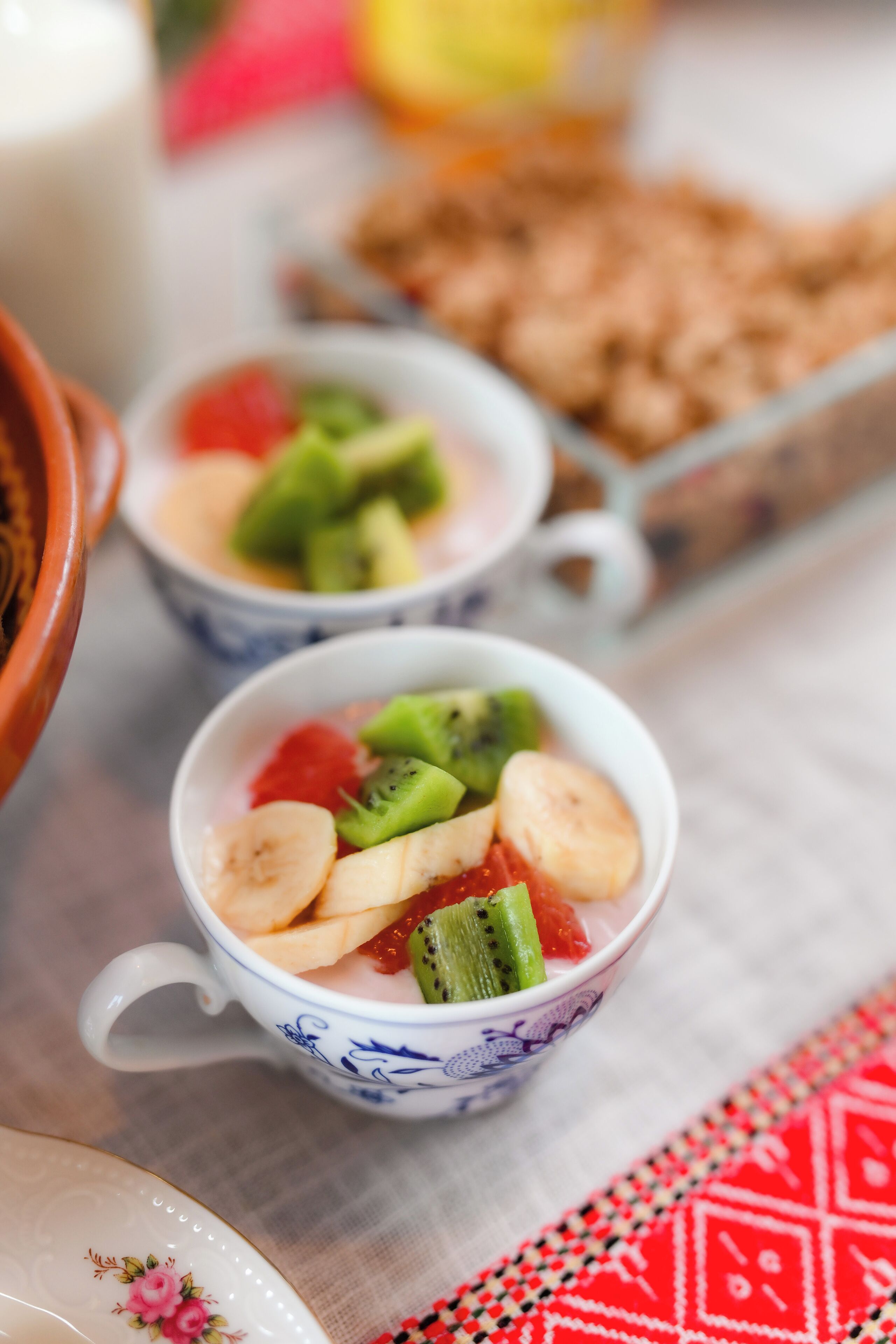 Two bowls of fruit salad with bananas, kiwi, and strawberries.