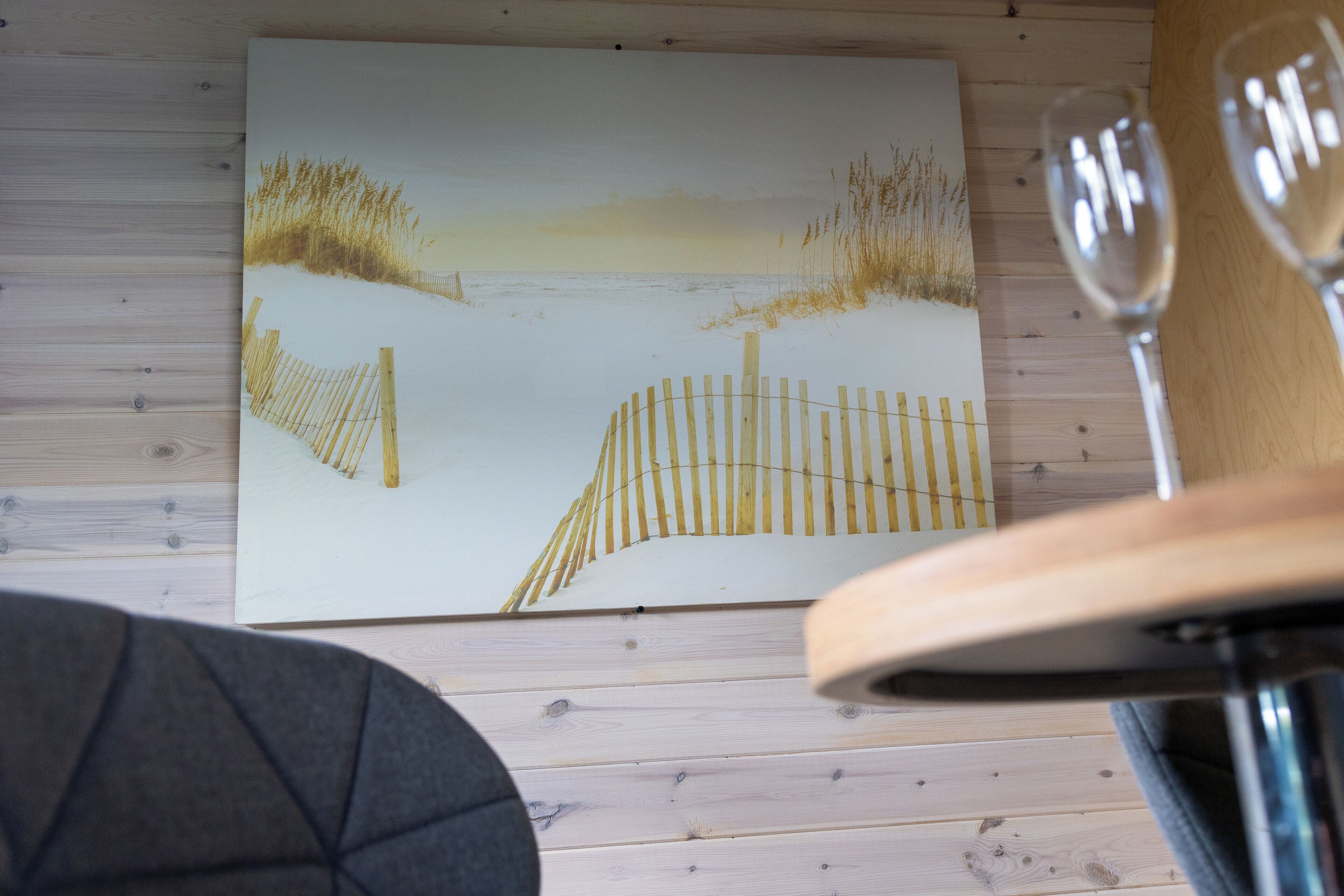 Een houten vloer met een lijstwerk kunstwerk dat een strandscène toont.