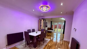 Un espace repas comprenant une table et des chaises, un radiateur et un luminaire fixé au plafond.