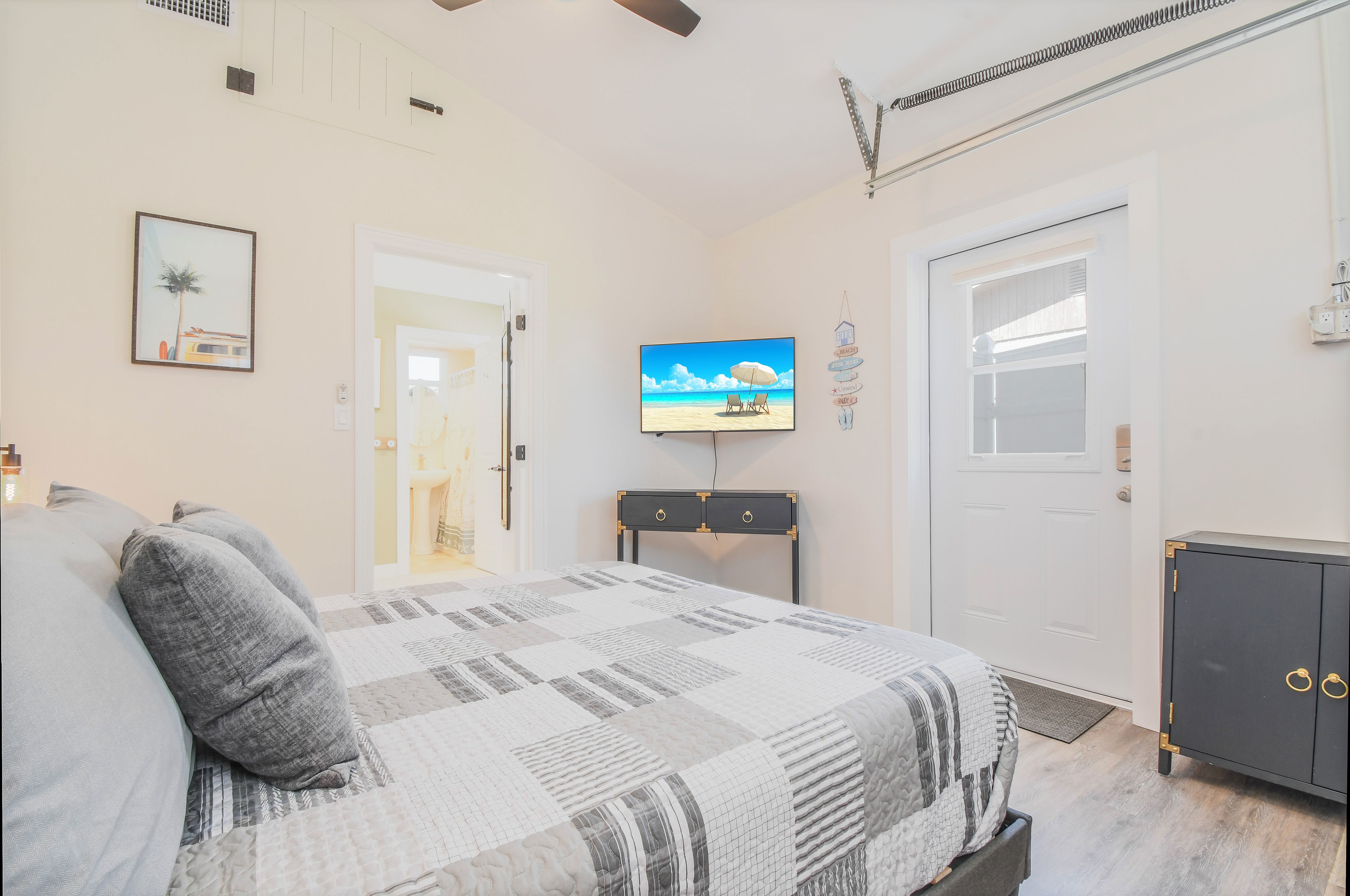 Una camera da letto con un letto, una televisione, un armadio e una porta.