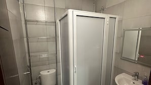 A bathroom with a toilet, a shower enclosure, and a sink. - Residence Ennasr 3 Hay Essalam (Hay Essalam)