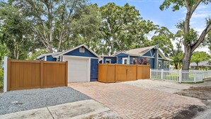 A residential property with a garage, a driveway, and a wooden fence. - GUEST HOUSE w/ PRIVATE ENTRANCE & PATIO for rent in Gulfport, FL (Gulfport)