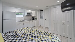 A compact bedroom with a bed, a wardrobe, and a small kitchenette. - GUEST HOUSE w/ PRIVATE ENTRANCE & PATIO for rent in Gulfport, FL (Gulfport)