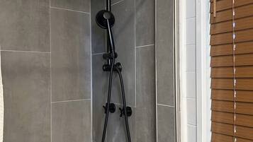 A shower with a handheld showerhead and a handheld hose.