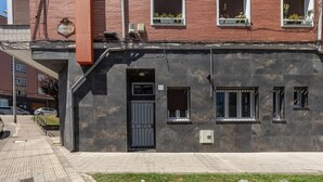 A building with a dark facade, a black door, and windows with white frames. - Hospital Cruces Metro Bec (Barakaldo)
