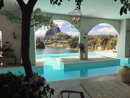 Una piscina al aire libre, sillones reclinables de piscina