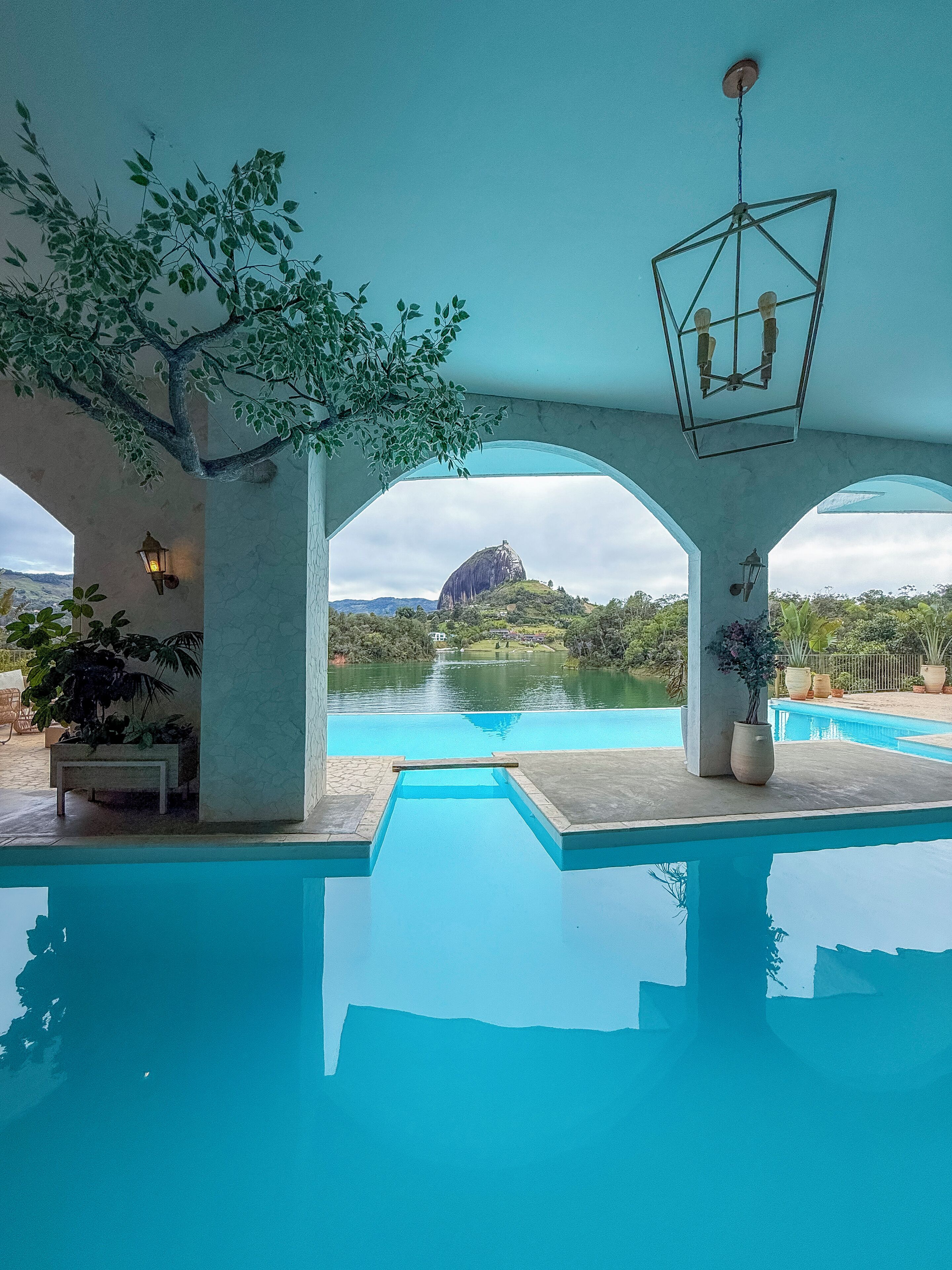 A swimming pool with a view of a mountain and a lake.