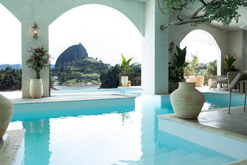 A pool area with a view of a mountain and a large vase.