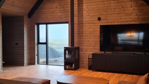 Ein gemütliches Wohnzimmer mit einem großen Fernseher, Holzmöbeln und einem Kamin.