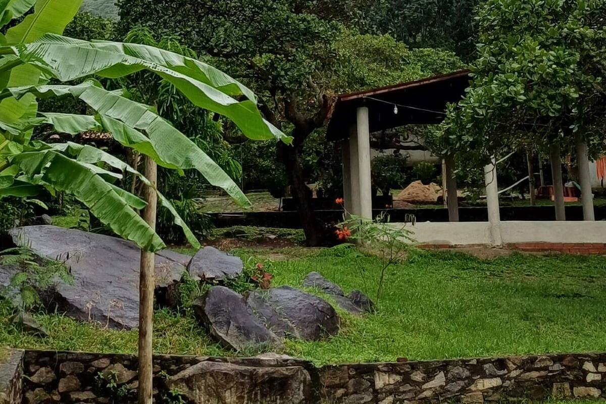 Un jardin agrémenté de gros rochers, d’un mur de pierres et d’une structure couverte.