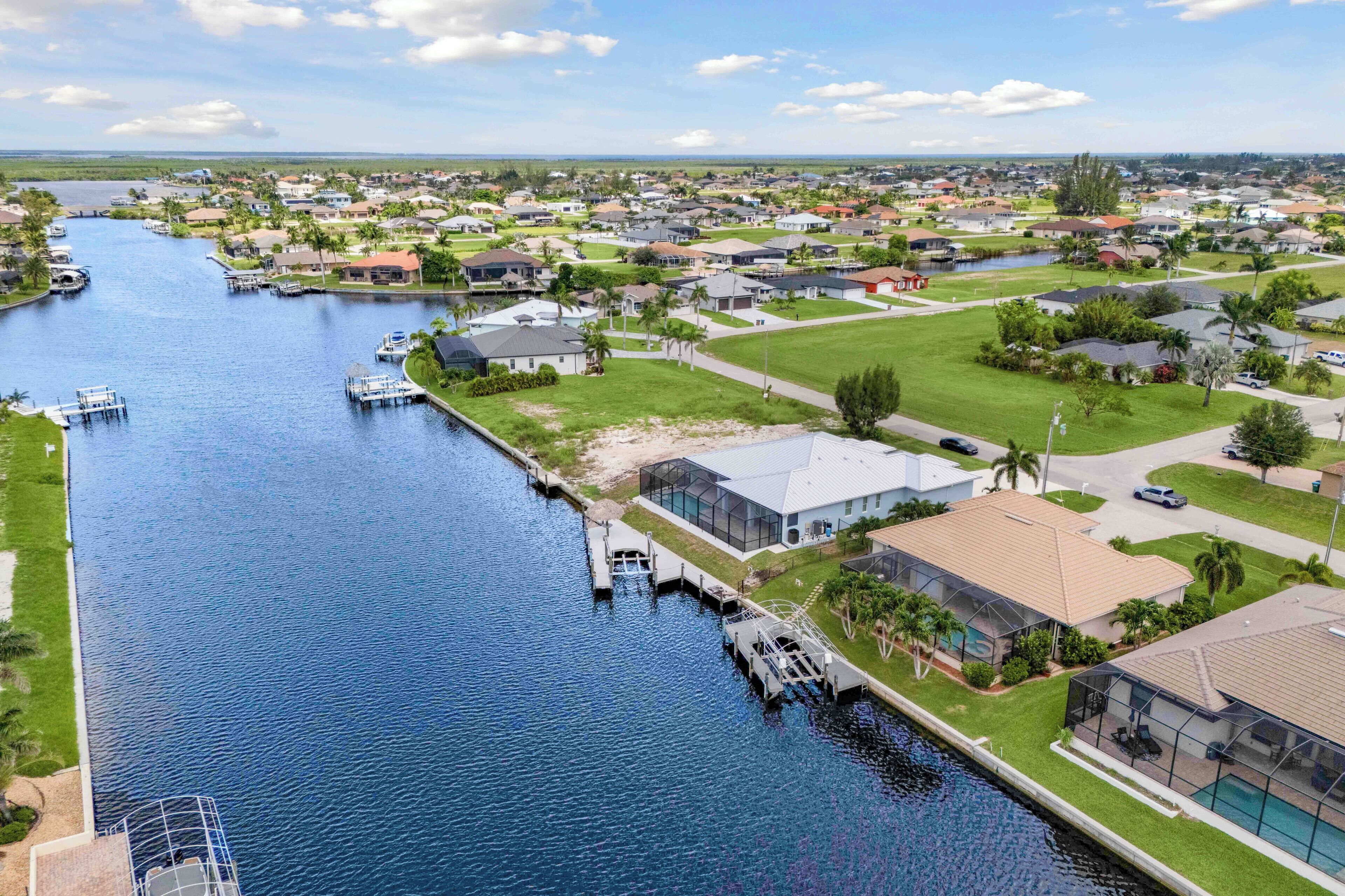 Et boligområde med en kanal, huse og en stor bygning med swimmingpool.