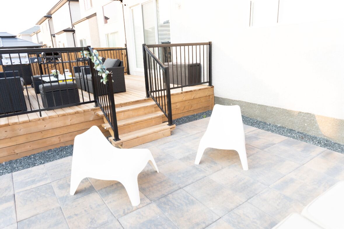 Un espace patio aménagé avec du mobilier d’extérieur, un escalier en bois et une rambarde.