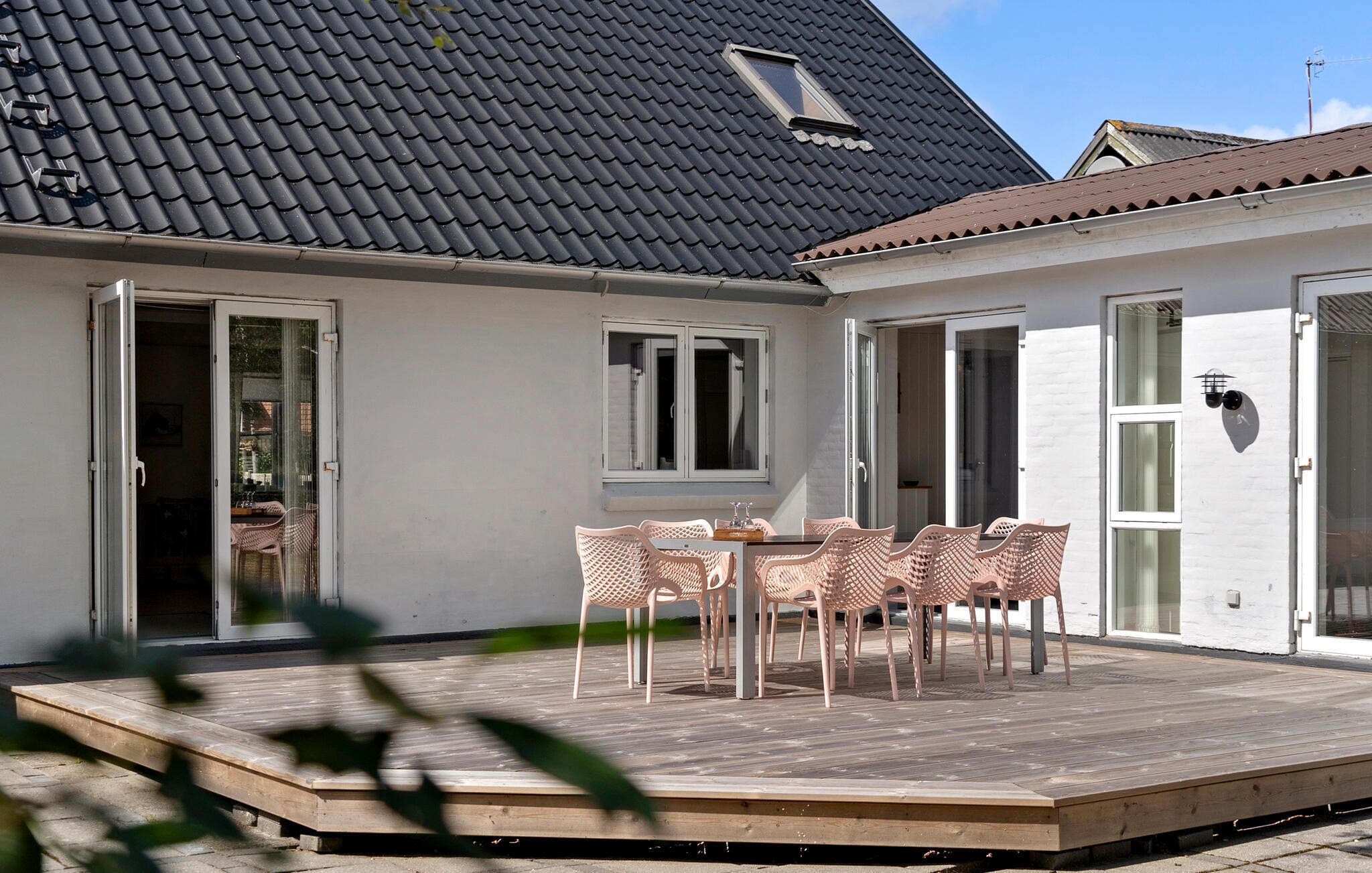 A patio with a table and chairs, a small window, and a door.