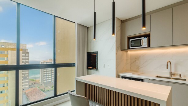 A modern kitchen with a large window, a built-in microwave, and a sleek countertop. - Apartments in the Turquesa Building - Balneario Picarras - RTS (Picarras)