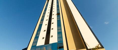 A tall hotel building with a modern design, featuring a prominent vertical structure and large windows.