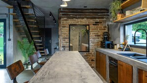 Una cocina moderna con una encimera larga, armarios de madera y una pared de ladrillo.