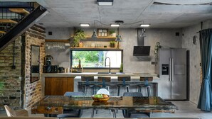 Una cocina moderna con una isla central, electrodomésticos integrados y un amplio ventanal con vistas al verdor.