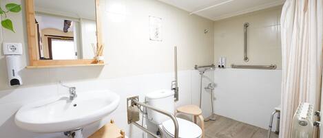 Un baño moderno con lavamanos, inodoro y ducha.