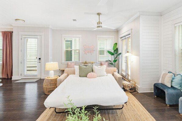 A bedroom with a large bed, a ceiling fan, a bedside lamp, and a plant. - Golf Cart, Bikes, Game Room, Walk to Big Chill, Minutes from Seaside & Rosemary (Santa Rosa Beach)
