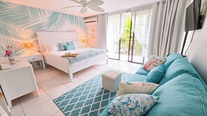 Un dormitorio moderno con una cama, un sofá, una mesita de noche y una ventana con cortinas.