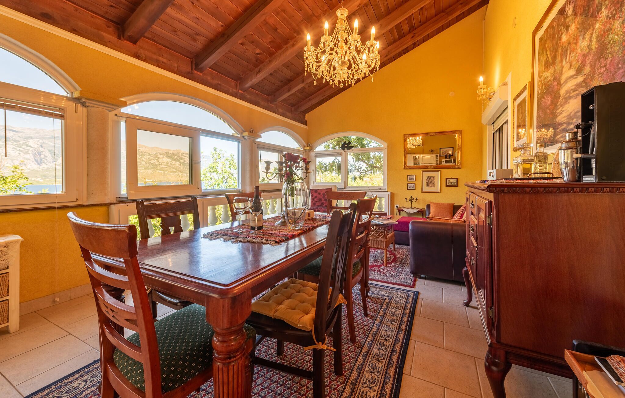 A dining area with a wooden table, chairs, and a chandelier.