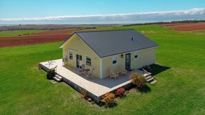 A single-story house with a deck, a small porch, and a large window. - Fun for the whole Family with a beautiful view! (French River)