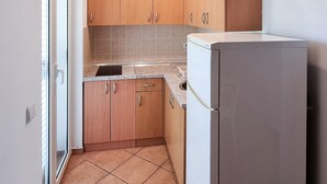 A compact kitchen with wooden cabinets, a built-in sink, and a stainless steel refrigerator. - Awesome apartment in Srima with WiFi (Srima)