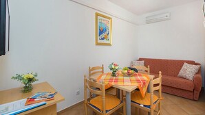 A small dining area with a table and chairs, a sofa, and a framed picture on the wall. - Awesome apartment in Srima with WiFi (Srima)
