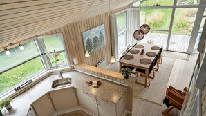 Una cucina moderna con un piano di lavoro in legno, un lavello incassato e una finestra che si affaccia su un giardino.
