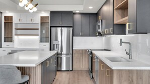 Una cocina moderna con una isla central, electrodomésticos de acero inoxidable y armarios de madera.