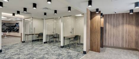 A modern office space with glass partitions, wooden accents, and patterned flooring.