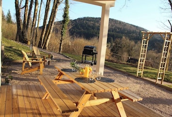 Terrasse couverte avec vue sur la montane, transat et barbecue